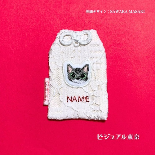 ペット名入れお守り。アメリカンショートヘアの顔を刺繍したお守り。優しい目元と赤い名入れ刺繍が特徴。SAWARA MASAKIデザイン・ビジュアル東京。